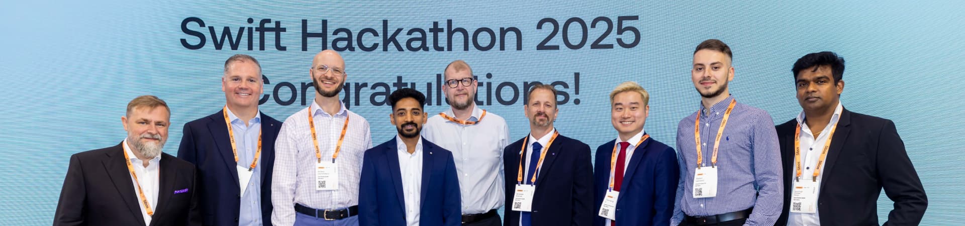 People standing in front of a Swift Hackathon 2025 screen.